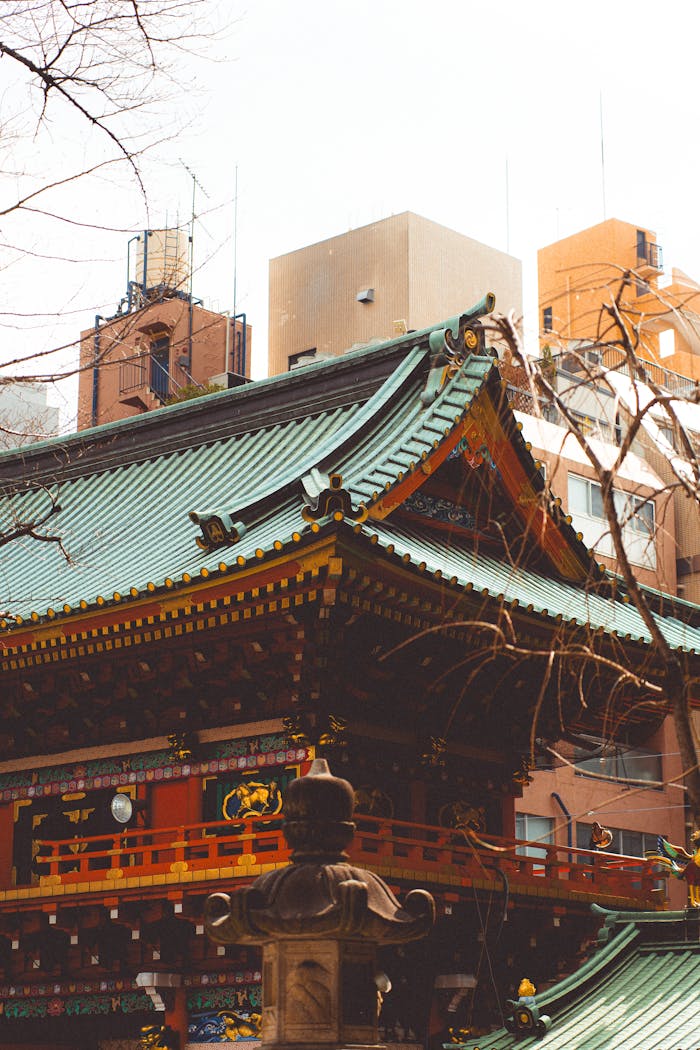 A traditional Japanese temple roof contrasts with modern Tokyo buildings, embodying cultural heritage.